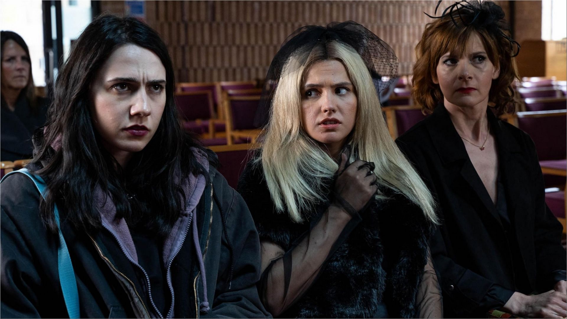 Josie, Billie, and Deb sit uneasily at the funeral as tensions rise within the family in Such Brave Girls season 2. (Image via Hulu)